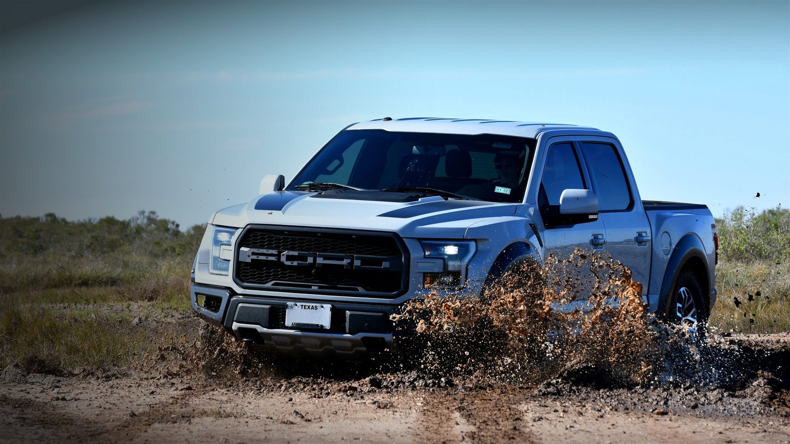 Ford F-150 Raptor kicking up mud off-road